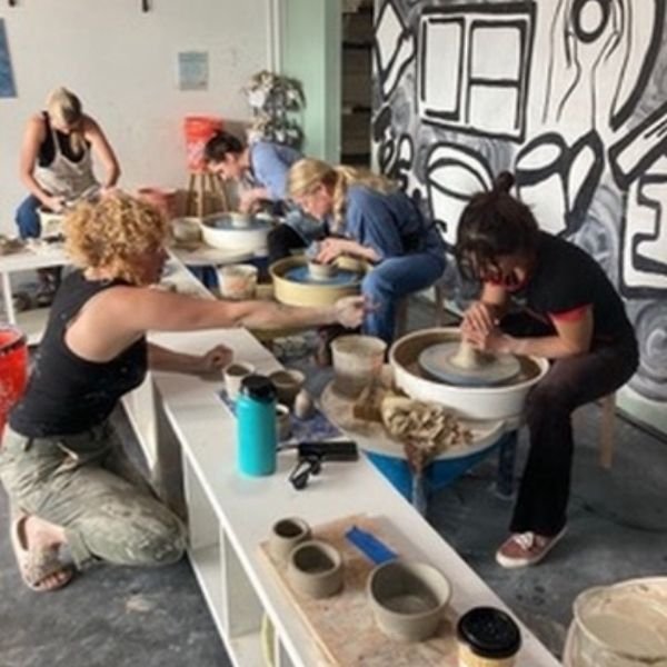 Pottery wheel workshop in Ocean Beach with adult students.
