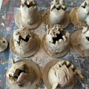 Kids displaying completed pottery pieces after glazing session.